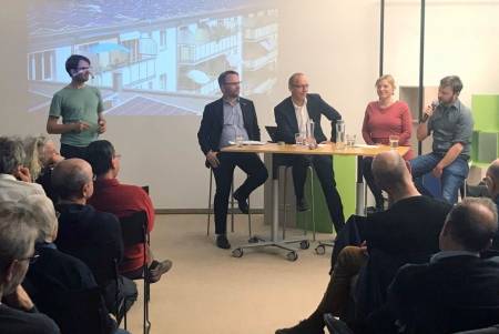 Diskussionsteilnehmer am Tisch vor dem Publikum