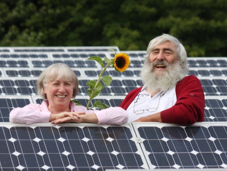 Ursula und Dr. Michael Sladek mit Sonnenblume, inmitten von Photovoltaik-Modulen