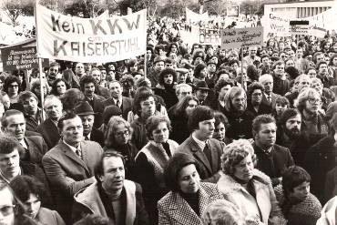 Archivaufnahme einer Demonstration gegen Atomkraftwerke in Wyhl, ein großes Transparent zeigt die Aufschrift "Kein KKW am Kaiserstuhl" 