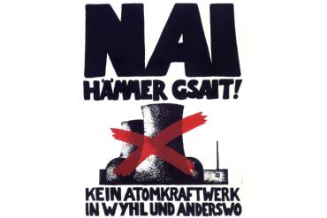 Ein gezeichnetes Atomkraftwerk, das durchgestrichen ist, darum steht der Schriftzug "Nai hämmer gsait! Kein AKW in Wyhl und anderswo"