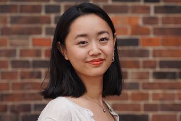 Portraitfoto von Valentine Zheng vor Ziegelmauer