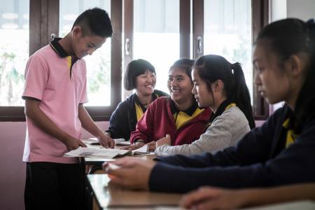 Ein Schüler hält vor seiner Schulklasse ein Referat