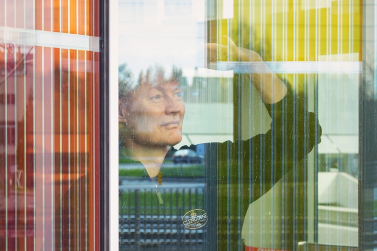 Michael Graetzel steht im Gebäude und schaut durch die Energieglas-Fassade