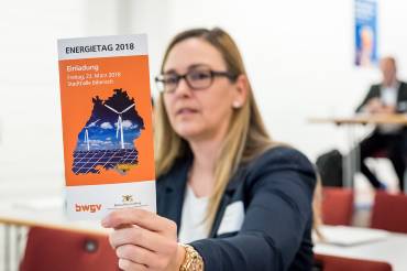 Eine Frau hält eine Broschüre zum Energietag 2018 in die Kamera.