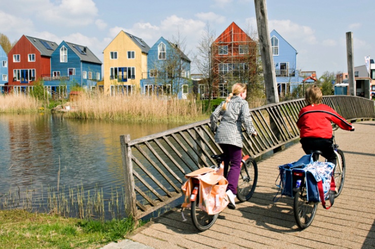 Blick über eine Brücke zur Siedlung mit bunten Häusern