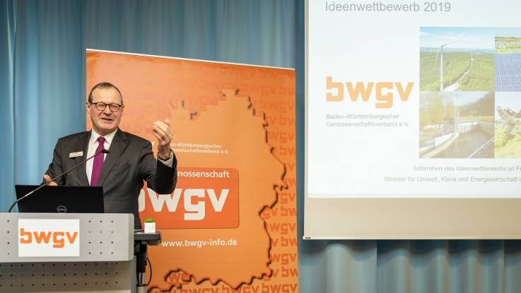 Ein Mann mit Brille steht am Podium und spricht.