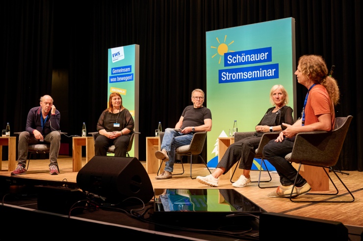 Auf der Bühne sitzen fünf Diskussionsteilnehmer im Halbrund.