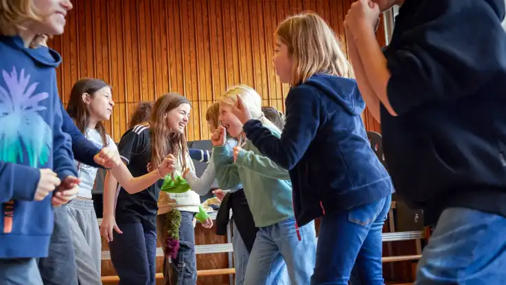 Die Kinder stehen sich nun paarweise gegenüber, während sie einander anschreien und dabei wild mit den Fäusten gestikulieren.