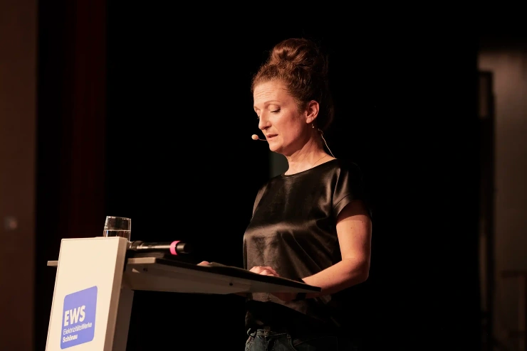 Eine Frau, Anja Burde, steht an einem Podium und spricht.