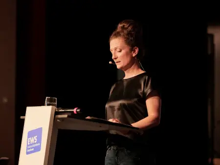 Eine Frau, Anja Burde, steht an einem Podium und spricht.