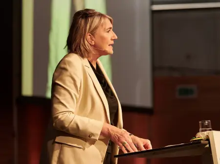 Eine Frau, Simone Peter, steht an einem Podium und spricht.