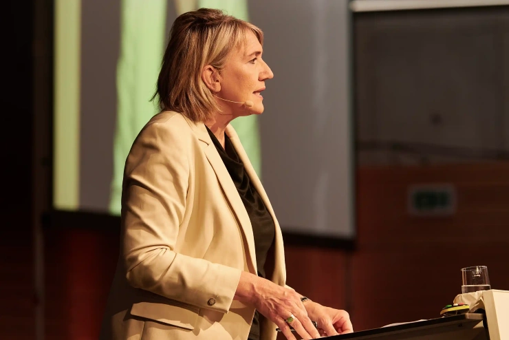 Eine Frau, Simone Peter, steht an einem Podium und spricht.