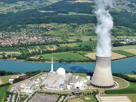 Luftbild des Atommeilers Leibstadt an einem Fluss in einer idyllischen Landschaft gelegen. Ein Dorf liegt in unmittelbarer Nähe.