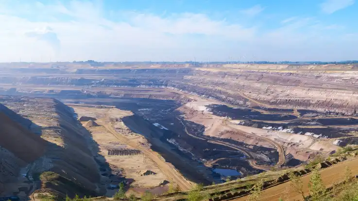 Die terrassierte Grube eines gigantischen Tagebaus verwandelt die Umgebung in eine Mondlandschaft. 