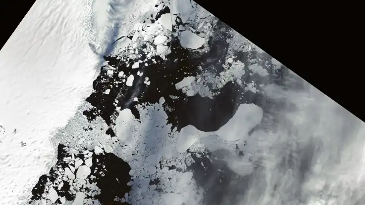 Eine Sattelten-Aufnahme zeigt unzählige Eisberge und Eischollen, die auf einem tiefschwarzen Ozean treiben. 