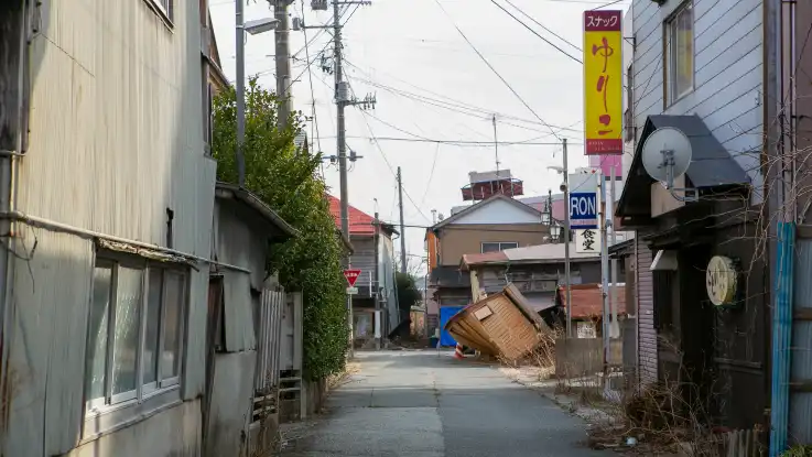  In einer Seitengasse zeigt sich das Ausmaß des Verfalls: Fassadenteile hängen herab und Gebäude stehen teils windschief da. 