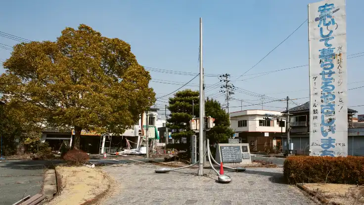 Ein menschenleerer Platz in einer Kleinstadt gesäumt von flachen, zweistöckigen Häusern.