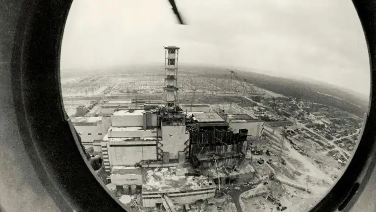 Schwarz-Weiß-Aufnahme aus dem Bullauge eines Helikopters: das Areal um den havarierten Block ähnelt einem Schlachtfeld. 