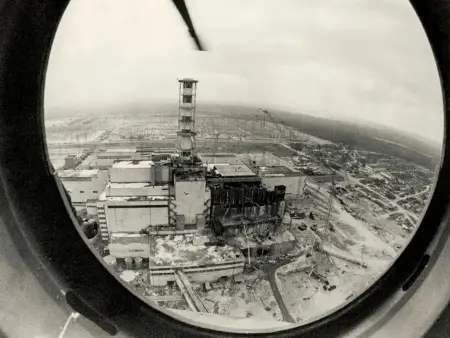 Schwarz-Weiß-Aufnahme aus dem Bullauge eines Helikopters: das Areal um den havarierten Block ähnelt einem Schlachtfeld. 