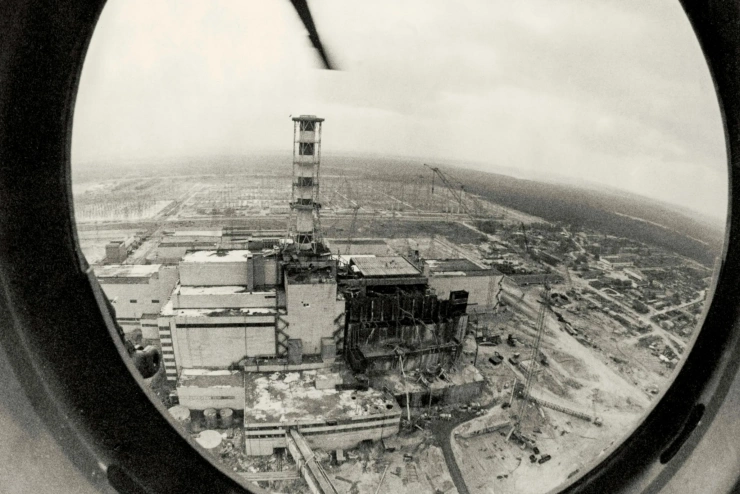 Schwarz-Weiß-Aufnahme aus dem Bullauge eines Helikopters: das Areal um den havarierten Block ähnelt einem Schlachtfeld. 