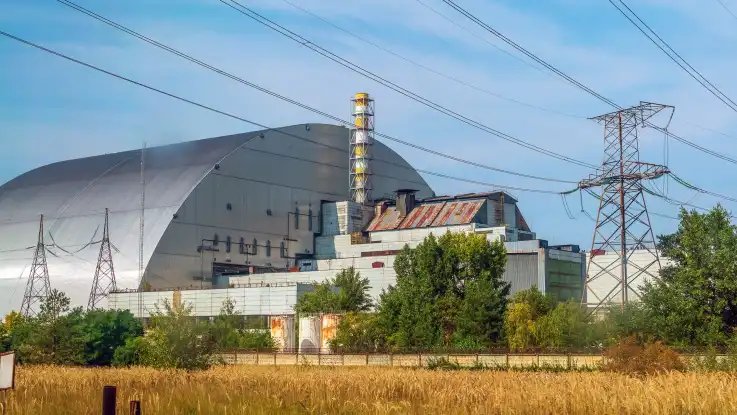 Totale: Eine gewölbte Halle aus Metall umhüllt weite Teile eines stillgelegten Reaktorblocks. 