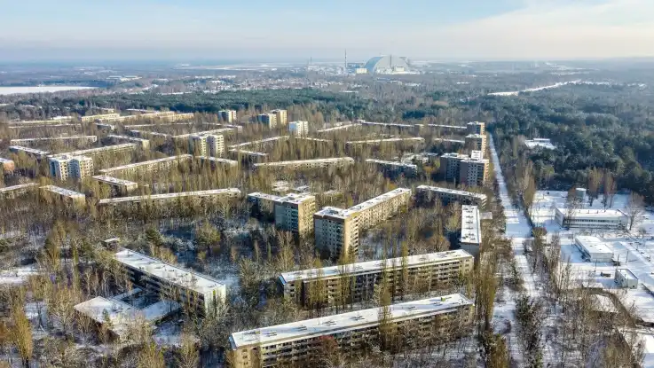 Luftaufnahme: Eine verlassene Plattenbausiedlung steht scheinbar mitten im Wald, die Straßen sind nicht mehr erkennbar. 