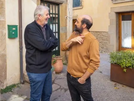 Zwei Männer stehen in einer Gasse und unterhalten sich angeregt. 