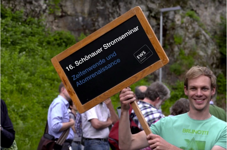 Junger Mann mit Tafel mit Aufschrift zum Stromseminar