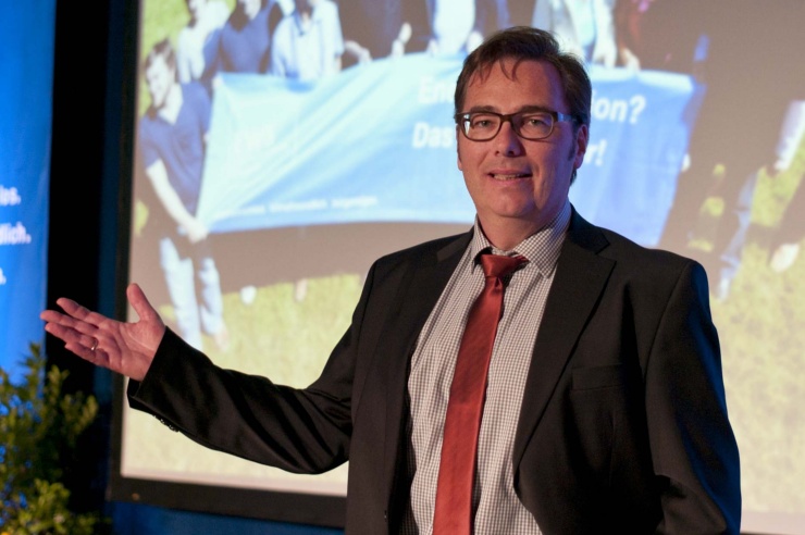 Prof. Dominik Kupfer hebt gestikulierend die rechte Hand