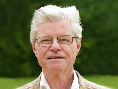 Portrait eines älteren grauhaarigen Mannes vor einem Waldrand