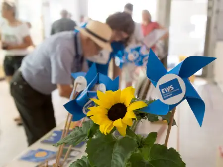 Vier Personen in lockerer Runde auf einem Podium, hinter ihnen Leuchtflächen mit den Aufschriften «Schönauer Stromseminar» und «Energie in Bürgerhand!»